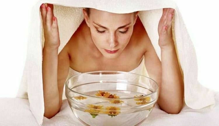 حمام البخار لتنظيف البشرة بعمق في المنزل، فتاة تضع وجهها فوق حمام ماء ساخن 